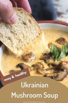 a person dipping some bread into a bowl of soup with mushrooms and parsley on top