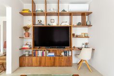 a living room with a large television on top of a wooden shelf