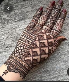 the hand is decorated with henna designs on it and has an intricate pattern that looks like