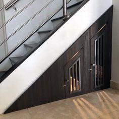 an escalator with wooden doors and metal handrails next to a wall