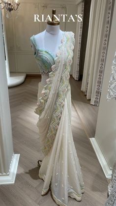 a white sari is displayed in front of a mannequin's head