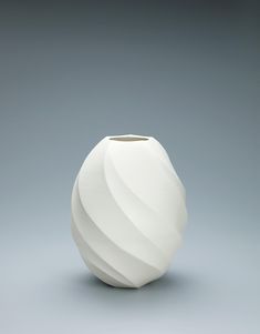 a white vase sitting on top of a table