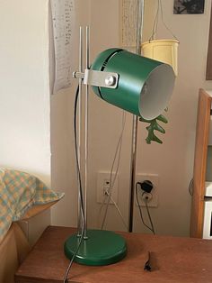 a green lamp sitting on top of a wooden table