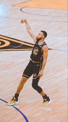 a basketball player is about to dunk the ball in an indoor court with his hand up