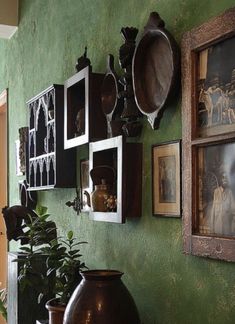 there are many pictures on the green wall