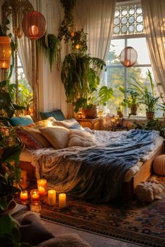 a bedroom with lots of plants and candles on the floor, in front of a window