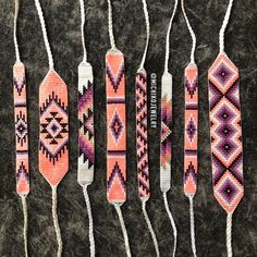 four handmade beaded ties are lined up on a black surface with white string