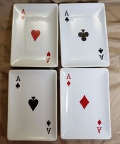 four playing cards are sitting on top of each other in front of a white plate