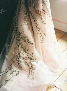 a woman in a wedding dress standing next to a window with her hands on her hips