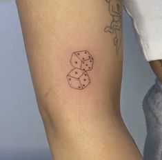 a woman's leg with dice tattoo on the left side of her arm, which is black and white