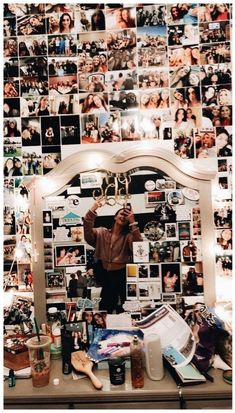 a man taking a selfie in front of a mirror with many pictures on it