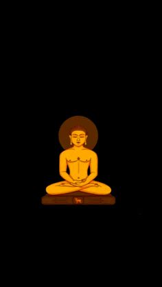 a buddha statue sitting on top of a wooden table in the dark with black background