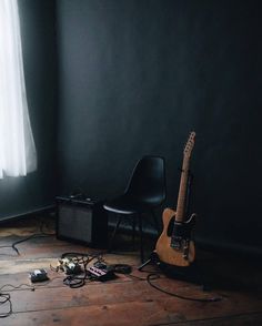 a guitar and amp sitting on the floor in front of a window