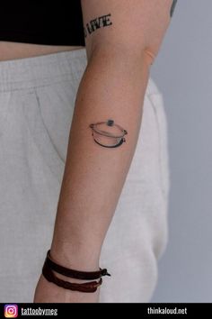 a woman's arm with a small tattoo on the left side of her arm