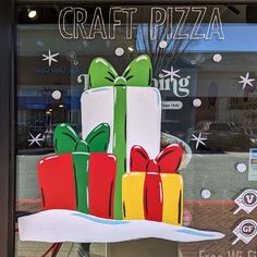 a window display with wrapped presents in front of the store's logo and name