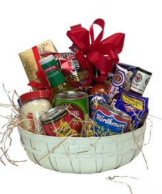 a white basket filled with lots of different types of food and candy items next to a red bow