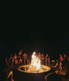 a group of people sitting around a fire pit