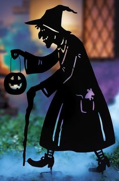 a silhouette of a man in a witches costume holding a jack - o'- lantern