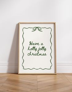 there is a framed christmas card on the floor next to a white wall and wooden floor