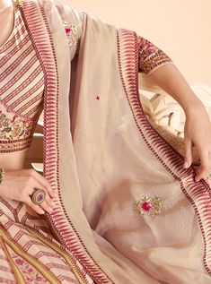 COLOR : Desert Sand FABRIC : Top (Blouse) - Premium Silk, Bottom (Lehenga) - Premium Silk, Inner - Cancan, Dupatta - Organza WORK : Silk Thread Embroidery, Sequins, Digital Print, Floral Motifs, Lace Border OCCASION : Wedding, Reception, Sangeet, Engagement READY-TO-WEAR : NoSTITCHING : Available as semi-stitched fabric, can be stitched using standard size option (+$30). Note: There might be a slight color variation due to lighting and flash used during photoshoot. The bright shade seen is the b Embroidered Dola Silk Sets For Wedding, Anarkali Georgette Lehenga For Traditional Ceremonies, Wedding Sets In Dola Silk With Embroidery, Wedding Sets With Embroidery In Dola Silk, Festive Georgette Lehenga With Motifs, Fitted Georgette Lehenga With Motifs, Semi-stitched Sets With Motifs In Traditional Drape, Floor-length Saree With Sheer Dupatta For Traditional Ceremonies, Embroidered Floor-length Sharara For Traditional Ceremonies