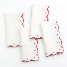 four white napkins with red trim and stars on the edges, sitting next to each other