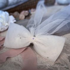 a white bow on top of a bed