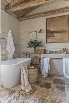 a large white bath tub sitting next to a sink in a bathroom under a wooden ceiling