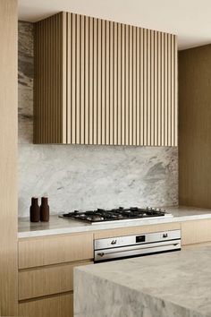 a modern kitchen with marble counter tops and wooden paneling on the back splashes