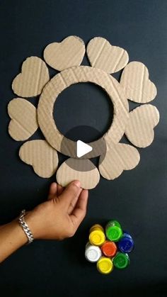 someone is making a paper flower wreath with paint and glue on the outside of it