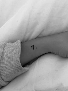 a person's foot with the letter t tattooed on their left leg, in black and white