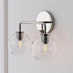 two clear glass globe lights on a white wall