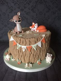 there is a cake decorated with animals on the top and bottom layer, along with bunting