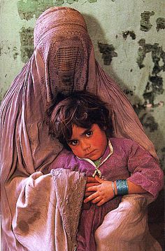 a young child sitting on the back of a woman's head in an old photo