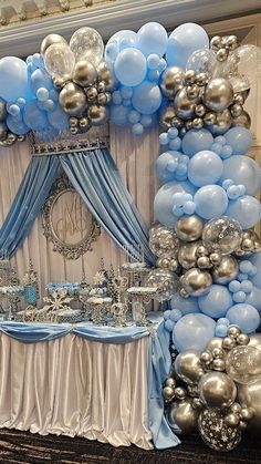 a blue and silver balloon arch is set up for a baby shower