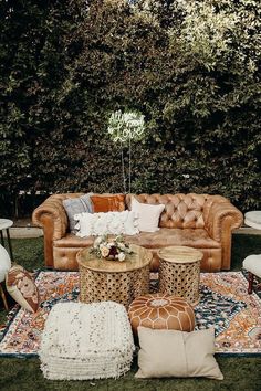 a living room filled with lots of furniture and pillows on top of a green field