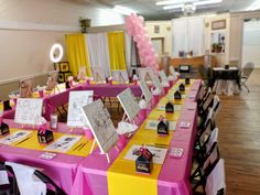 the tables are decorated with pink and yellow tablecloths, black chairs, and pictures on them