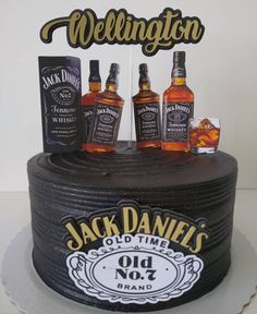 a birthday cake with three bottles of whiskey on top