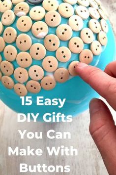 a person is pointing to buttons on a blue container with the words 15 easy diy gifts you can make with buttons