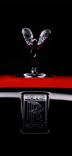 the hood ornament of a rolls royce car is shown in black and red