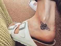 a woman's foot with a bee tattoo on it