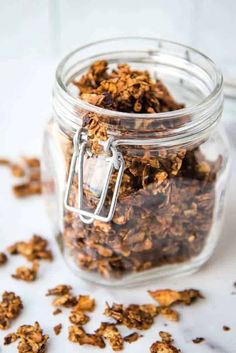 a glass jar filled with granola sitting on top of a table