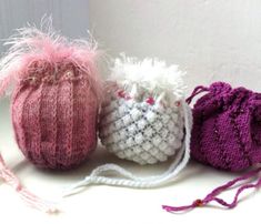 three small crocheted bags sitting next to each other on a white counter top