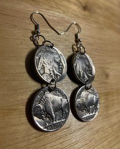 These earrings are made from authentic 1930s US Buffalo Nickel Coins. On the front side of the earring it shows both sides of the same coin one depicting an American Bison (Tails) and the other side depicting a Native American (Heads). The nickels are made from nickel and the earring is made of authentic silver. Both coins (4 in total) is the same size as a current day nickel. Vintage Brass Earrings With Engraving, Vintage Silver Medallion Earrings, Vintage Engraved Brass Earrings, Vintage Brass Earrings With Engraved Details, Nickel-free Vintage Jewelry For Souvenirs, Vintage Nickel-free Jewelry Souvenir, Vintage Silver Coin Earrings, Vintage Antique Silver Coin Jewelry, Vintage Coin Pendant Earrings Gift