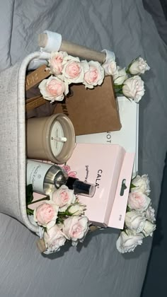 the contents of a woman's purse laid out on top of a bed with flowers