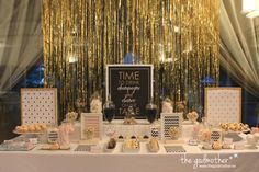 the dessert table is set up for a wedding reception with gold sequins hanging from the ceiling