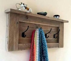 a wooden coat rack with hooks and scarves on it