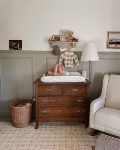 a baby laying on top of a wooden dresser