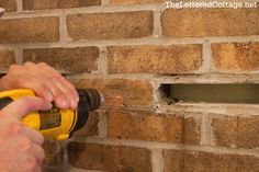 a person using a drill to fix a brick wall