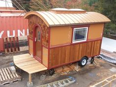 a tiny house sitting on top of a wooden platform