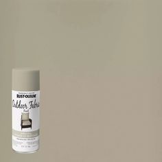 a white spray paint can sitting on top of a gray wall next to a brown chair